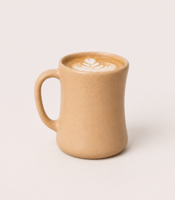 Bamboo Travel Coffee Mug in sandy brown matte finish on a wooden table